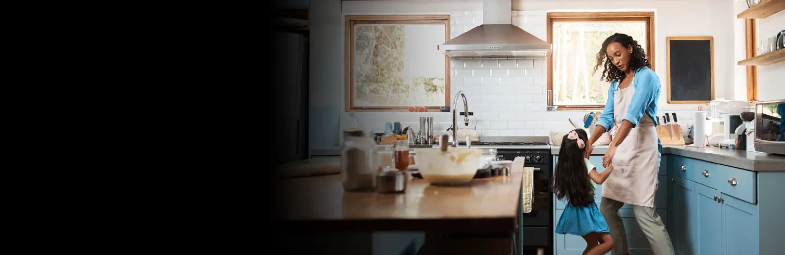 Mother and daughter dancing in kitchen